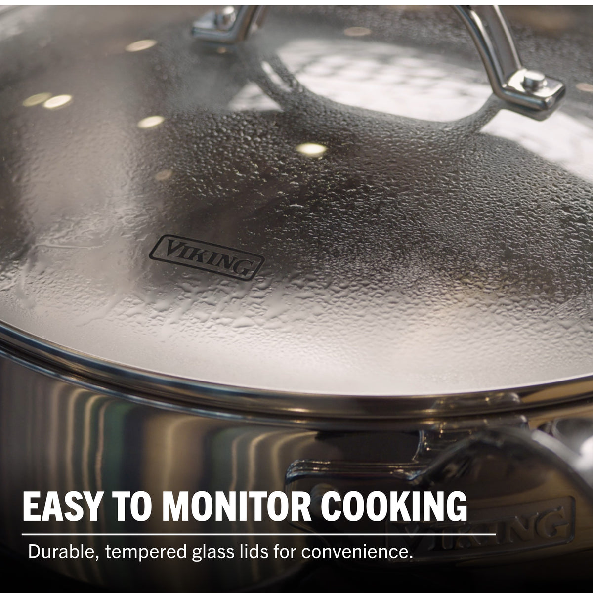 A close-up of the Viking Artisan 3-ply Stainless Steel 11-Piece Cookware Set with condensation on its tempered glass lid. The text: Easy to monitor cooking. Durable glass lids for convenience. Induction compatible by Viking Culinary Products.