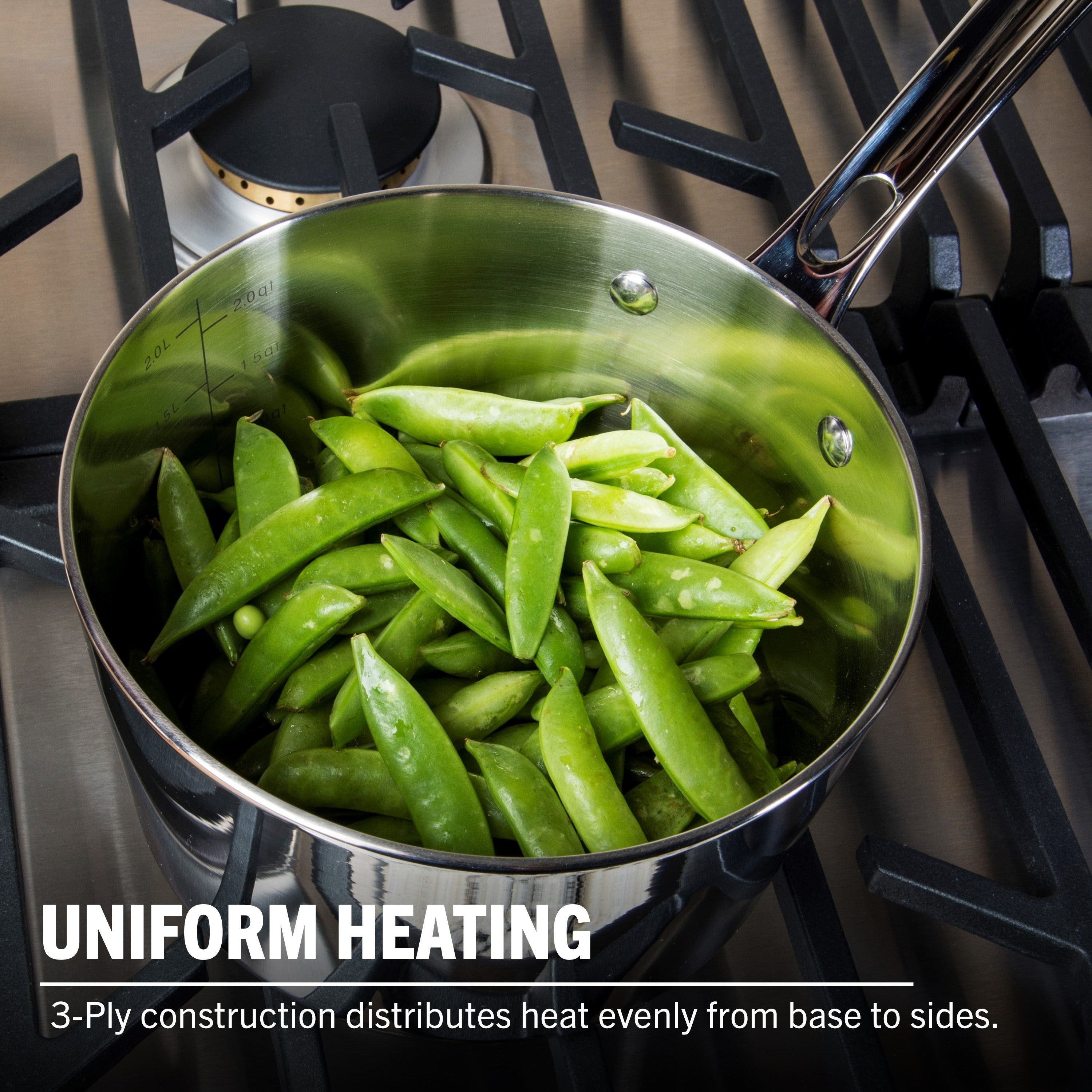 A Viking Contemporary 3-Ply 3.4-Quart Sauce Pan with Glass Lid from Viking Culinary Products, filled with fresh snap peas on a gas stove. Text: Uniform Heating—induction compatible stainless steel provides even heat from base to sides.