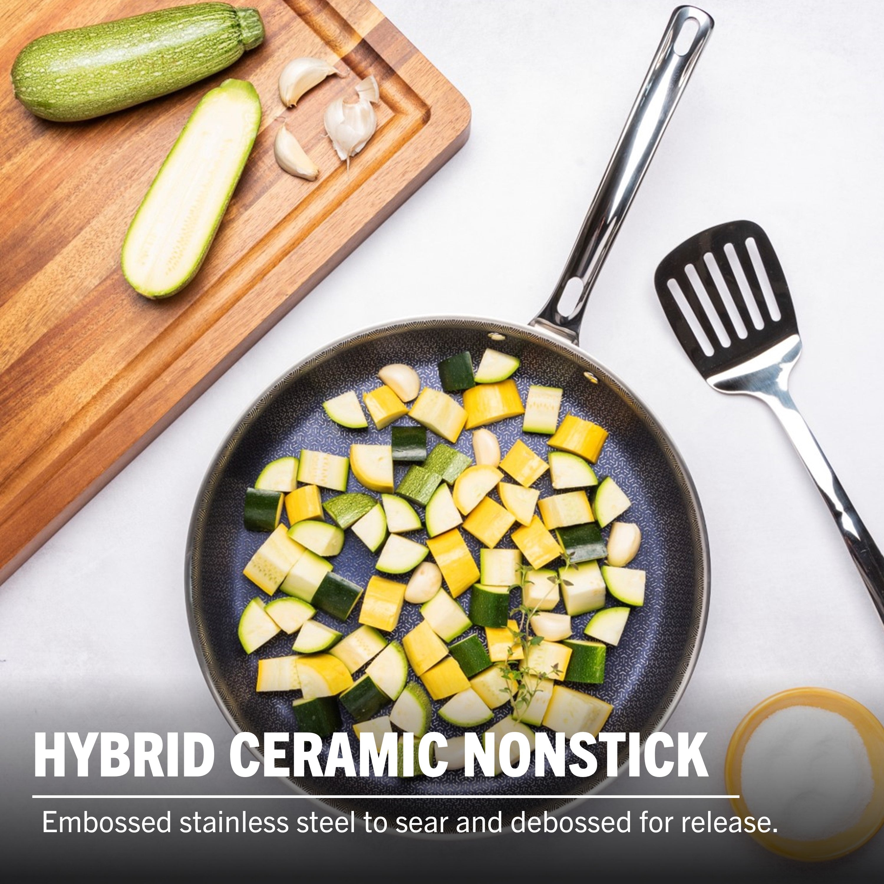 A Viking Culinary Products 12-inch 3-Ply Hybrid Plus Ceramic Nonstick Fry Pan holds chopped zucchini and garlic beside a spatula, a cutting board with sliced zucchini, and a bowl. Text: Induction-capable hybrid ceramic nonstick cookware.