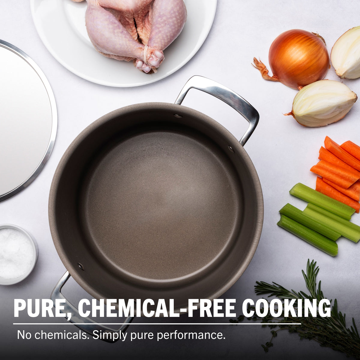 The Viking PureGlide Pro 3-Ply 8-Quart Stock Pot with Metal Lid from Viking Culinary Products sits on a kitchen counter with chicken, onions, carrots, celery, salt, and herbs. Cook chemical-free for pure performance—no chemicals, just quality cooking.