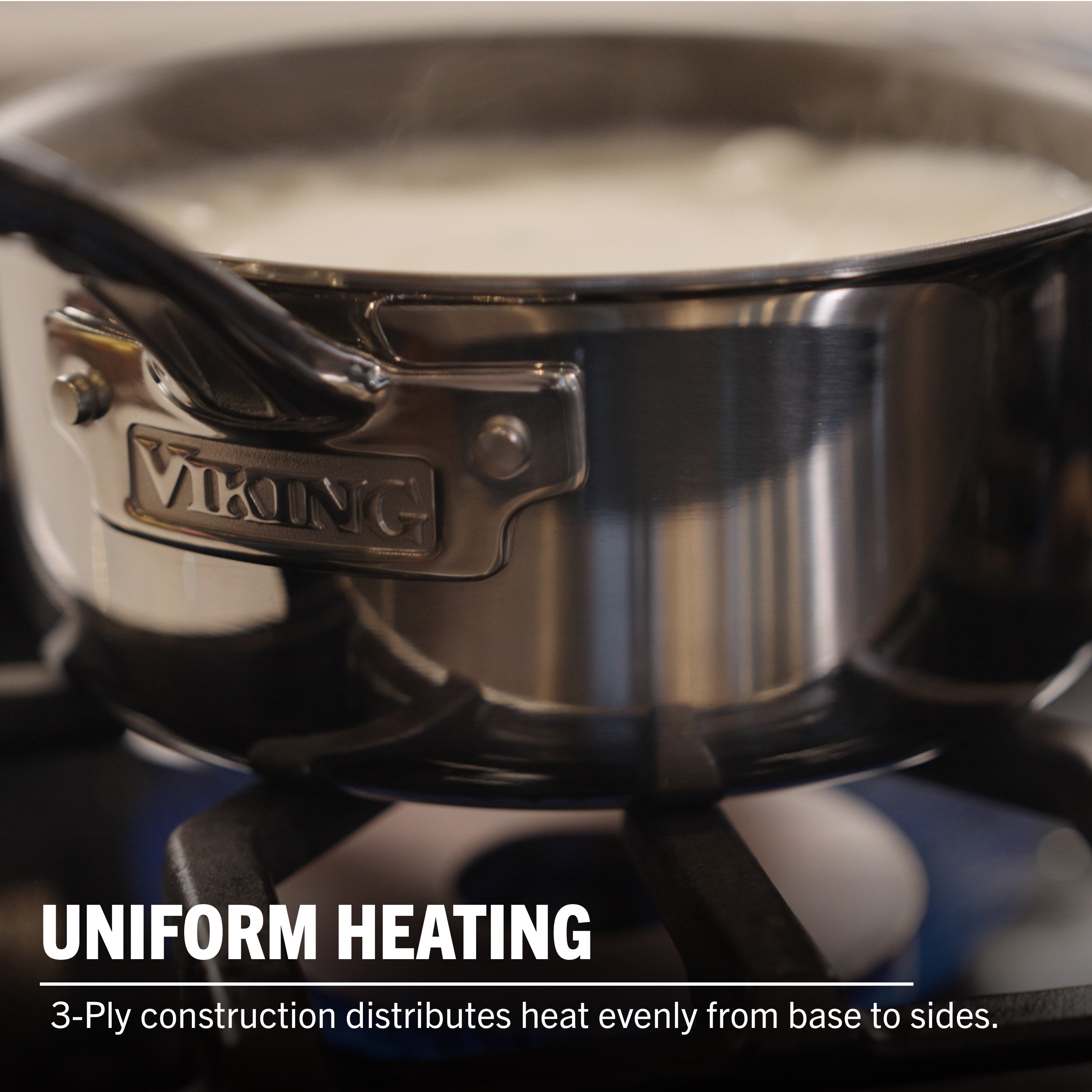 A Viking Culinary Products PureGlide Pro 3-Ply 3-Quart Sauce Pan with metal lid sits on a gas stove as liquid boils. Text: Uniform Heating—Tri-ply construction ensures even heat distribution from base to sides.