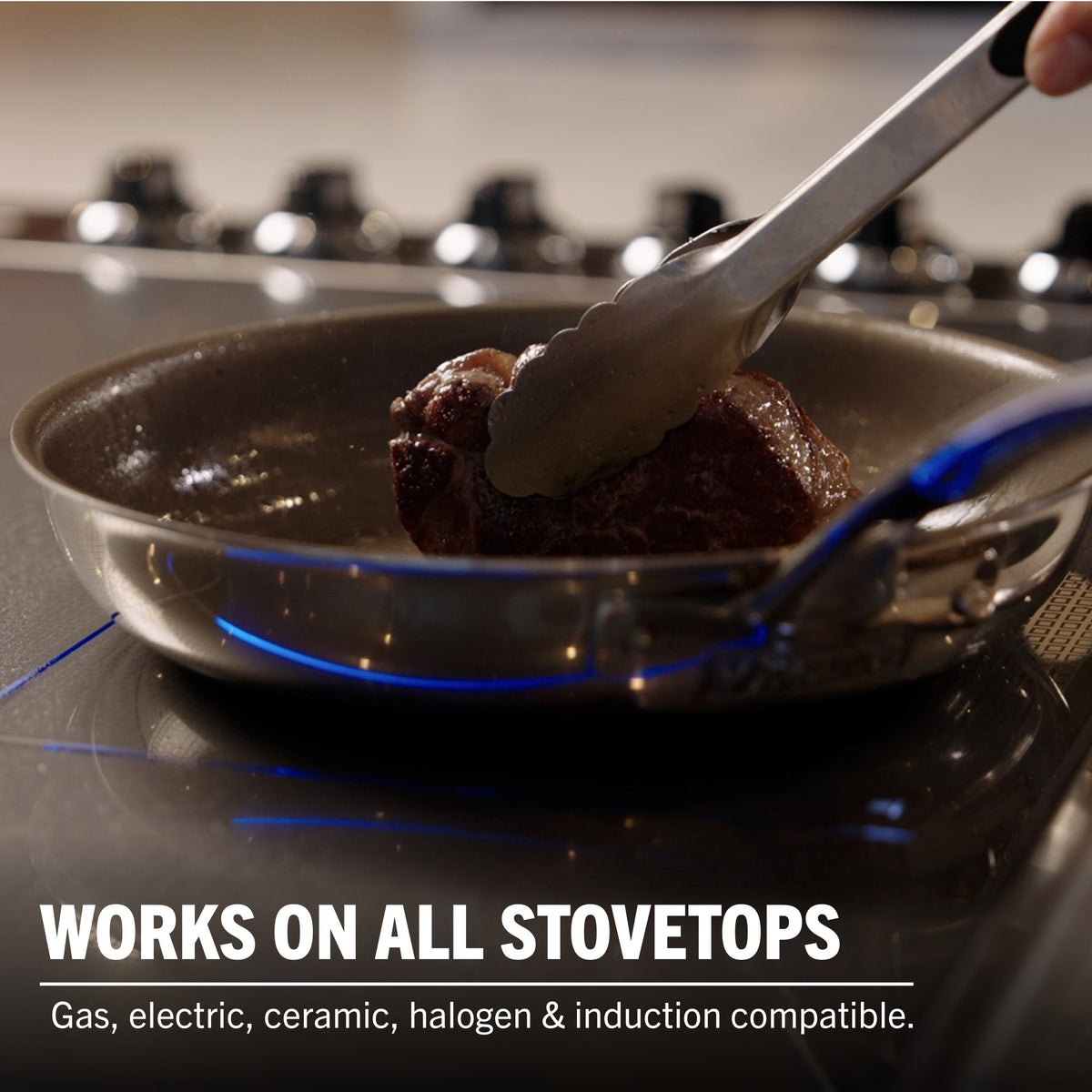 A hand sears meat with tongs in a Viking PureGlide Pro 3-Ply Fry Pan from Viking Culinary Products. Works on all stovetops—gas, electric, ceramic, halogen & induction—making it perfect for healthy cooking. Set includes 9.5" and 11" pans.