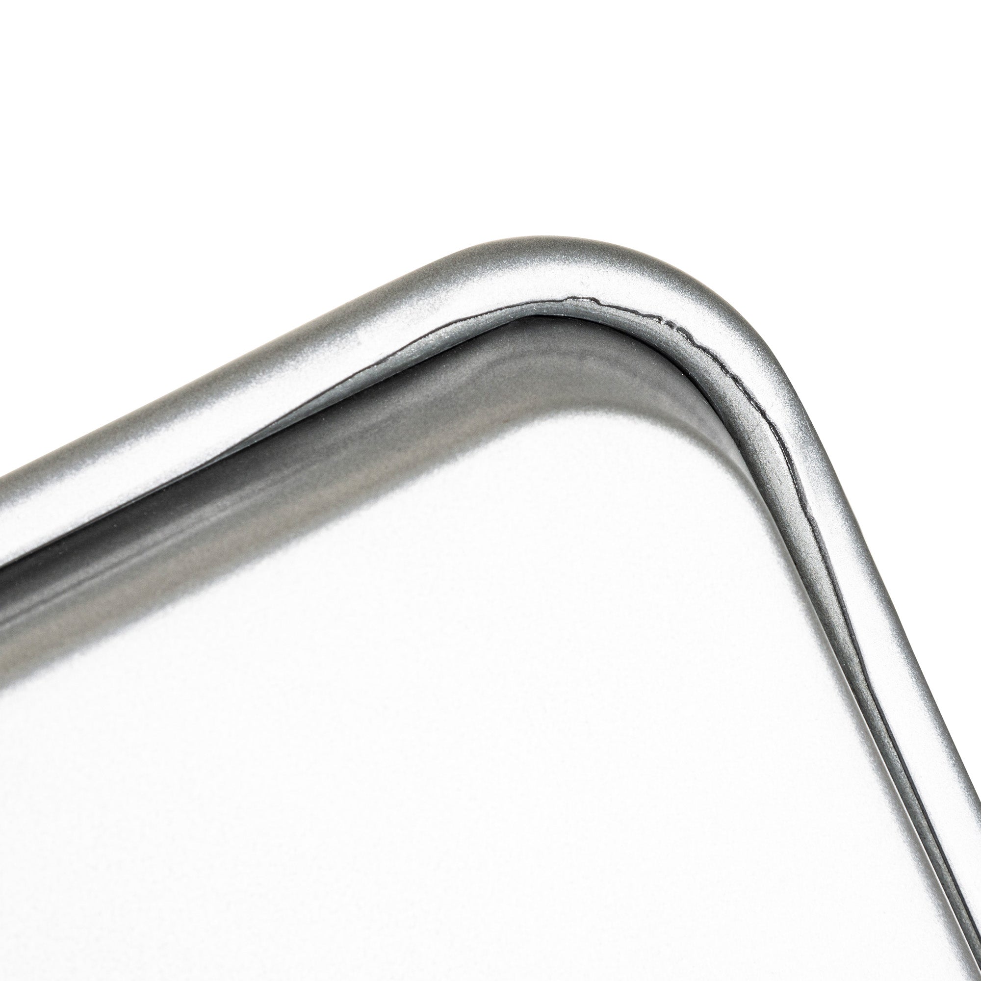 Close-up of a rounded metal corner on the Viking 3-Piece Nonstick Aluminized Steel Baking Sheet Set by Viking Culinary Products, featuring a smooth, shiny silver finish and a visible seam along the bend.