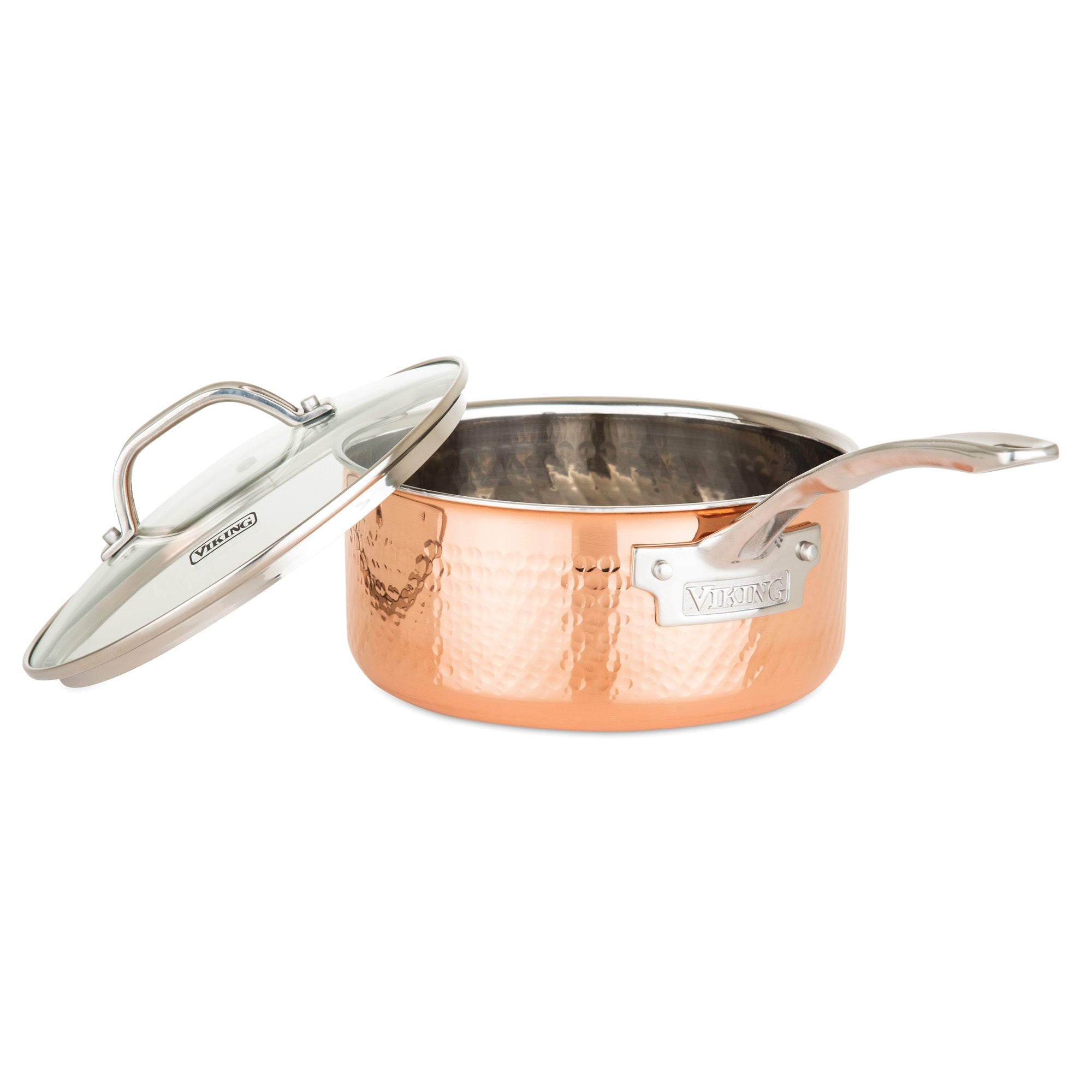 The Viking 3-Ply Hammered Copper Clad saucepan from Viking Culinary Products features a stainless steel interior, ergonomic handle, glass lid, and “Viking” engraving on both the pan and lid for a stylish and durable kitchen essential.