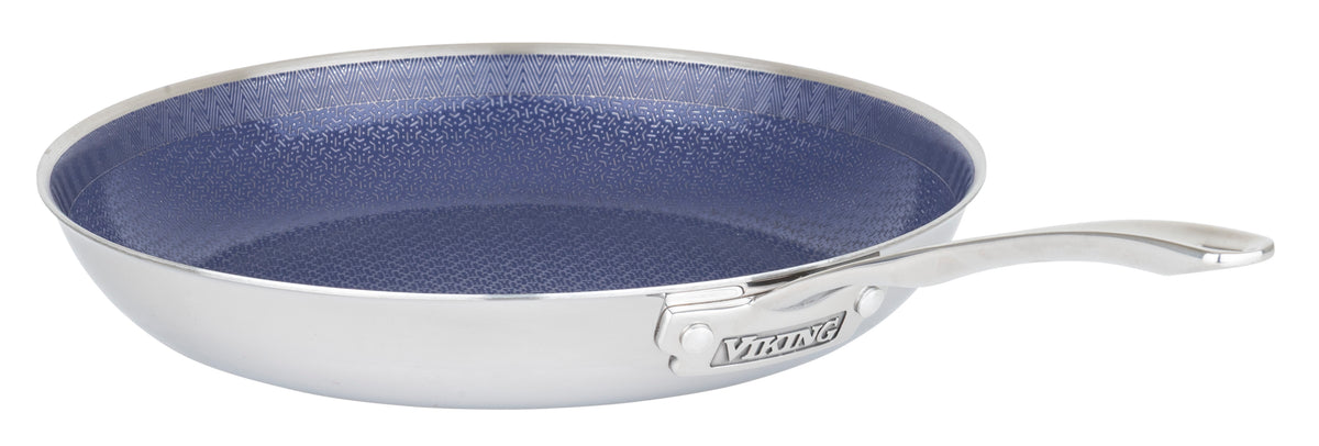 The Viking 3-Ply Hybrid Plus Ceramic 12-inch Nonstick Fry Pan by Viking Culinary Products features a stainless steel, 3-ply design, blue textured nonstick interior, curved metal handle, and an induction-ready base engraved with the brand name.