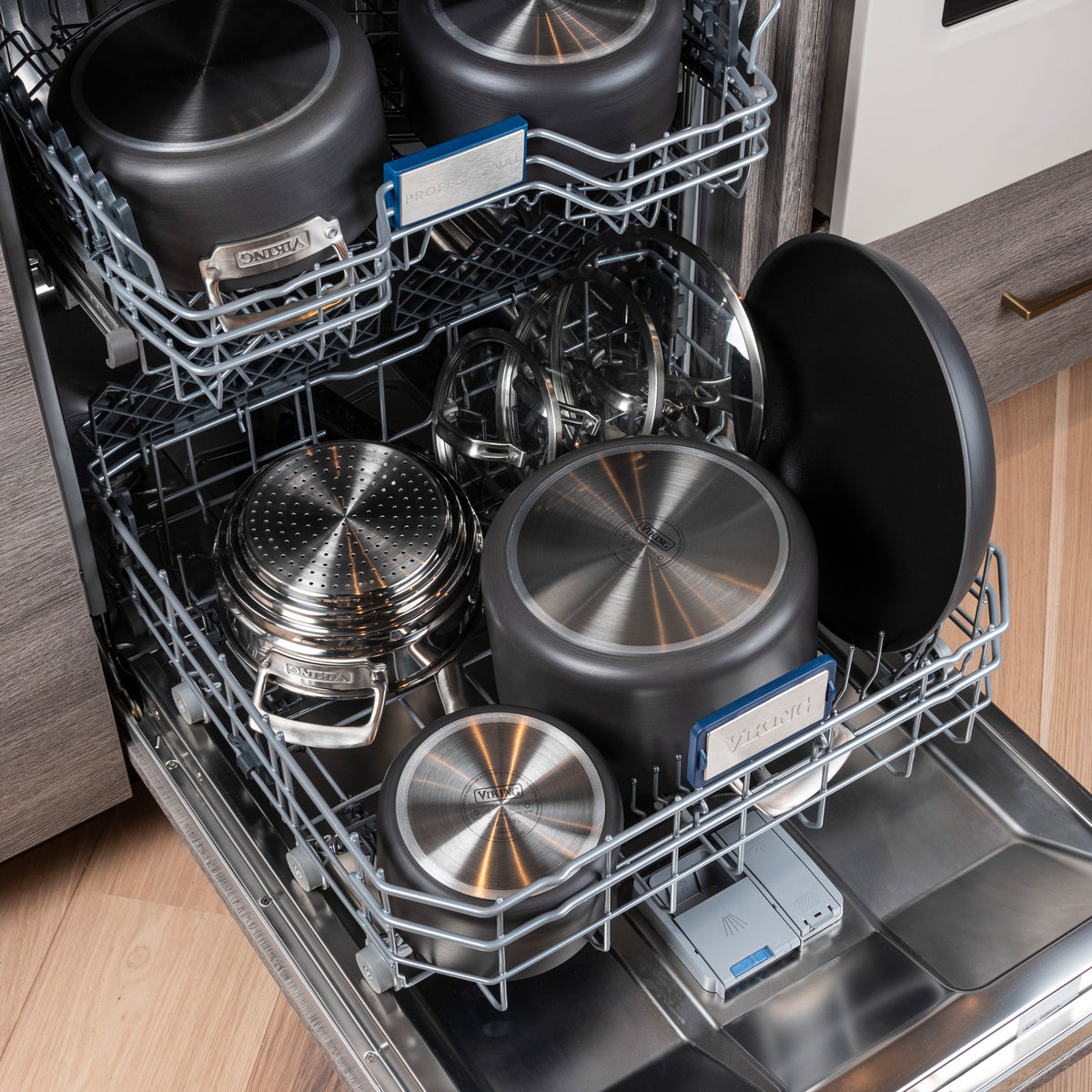 Open dishwasher loaded with the Viking Culinary Products Hard Anodized Nonstick 15-Piece Cookware Set with glass lids, all neatly arranged and ready to wash.