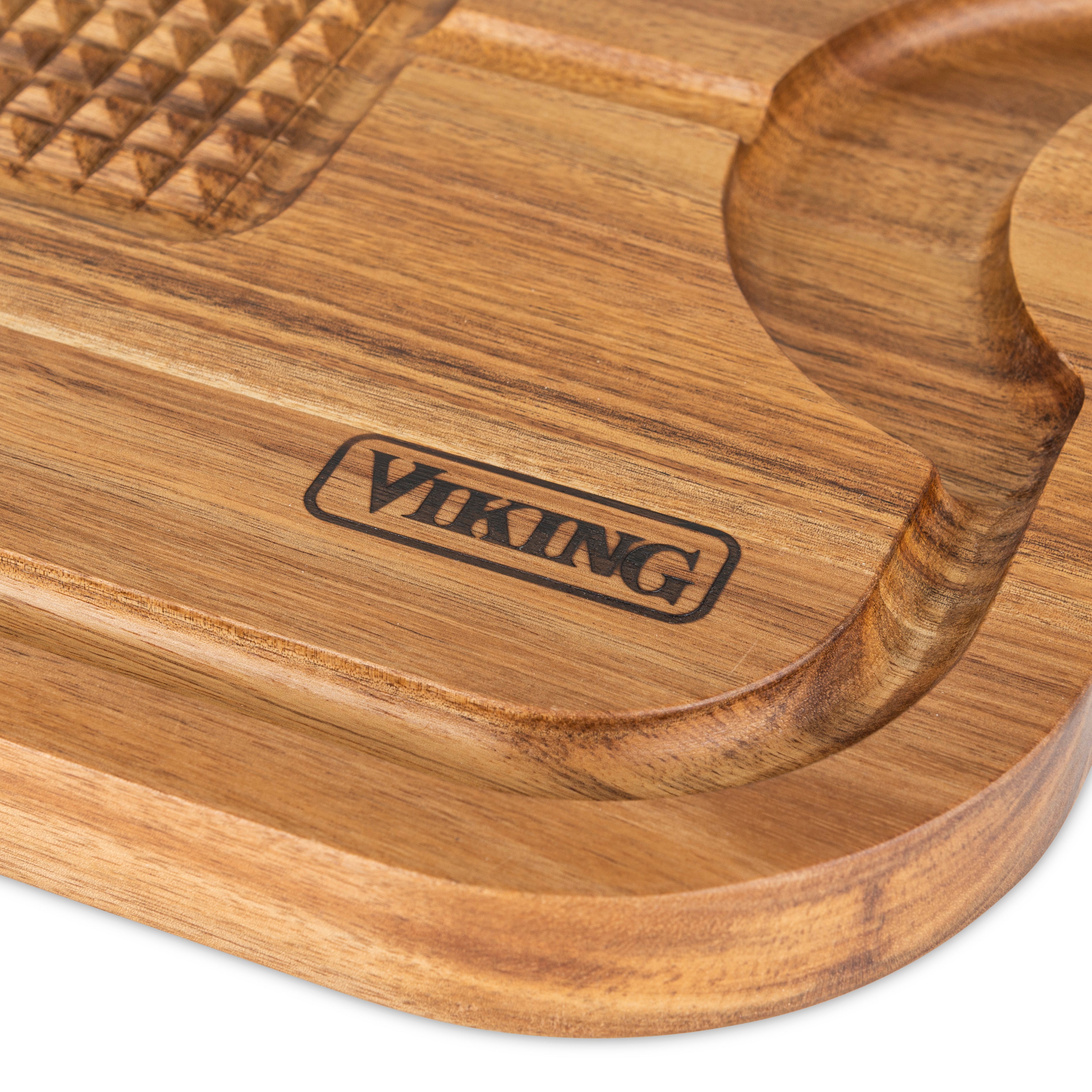 Close-up of a wooden cutting board with the word VIKING engraved on it. The board features a grooved edge and a textured section for gripping or tenderizing.