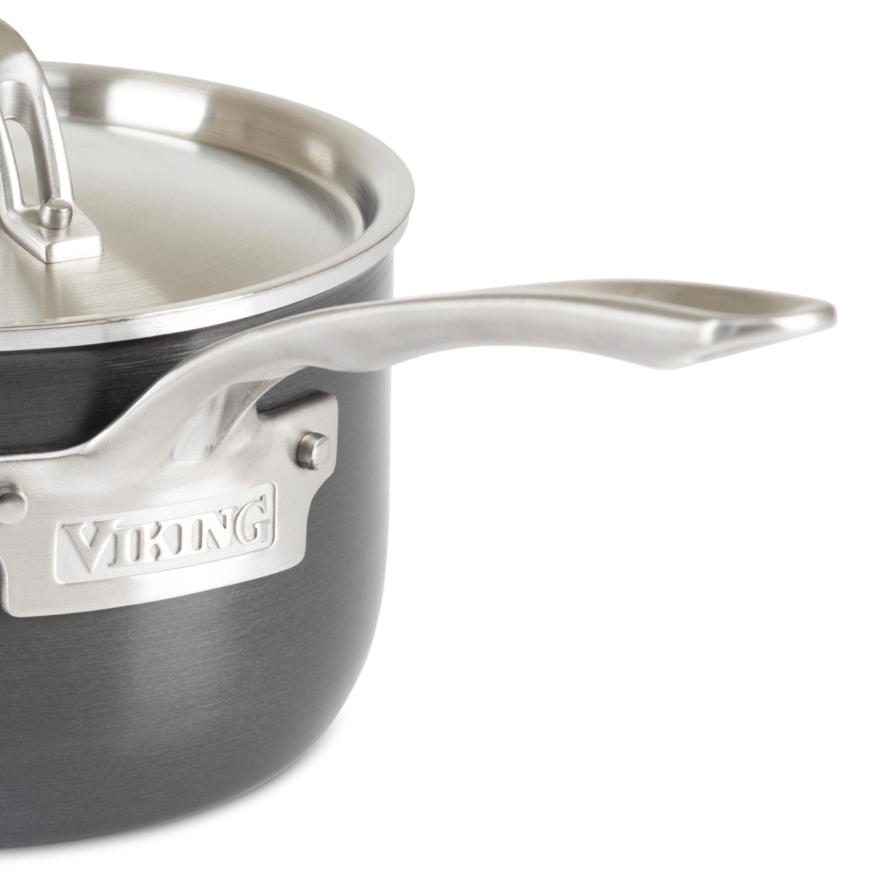 A close-up of a Viking saucepan with a metal handle and lid. The pot is dark gray with a brushed finish, and the Viking brand name is engraved on a metal plate attached to the handle.