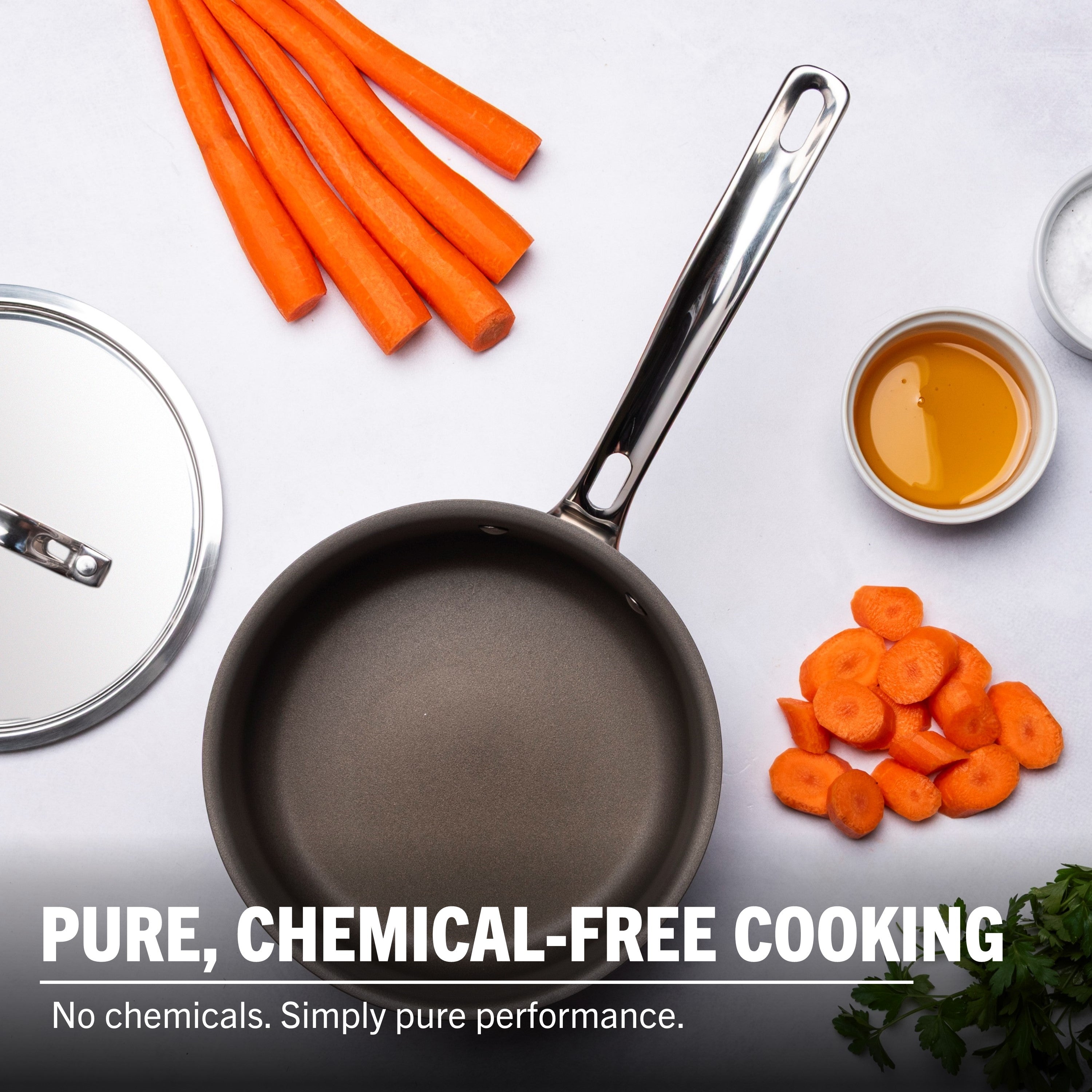 Frying pan with carrots and other ingredients on a white background, emphasizing chemical-free cooking.
