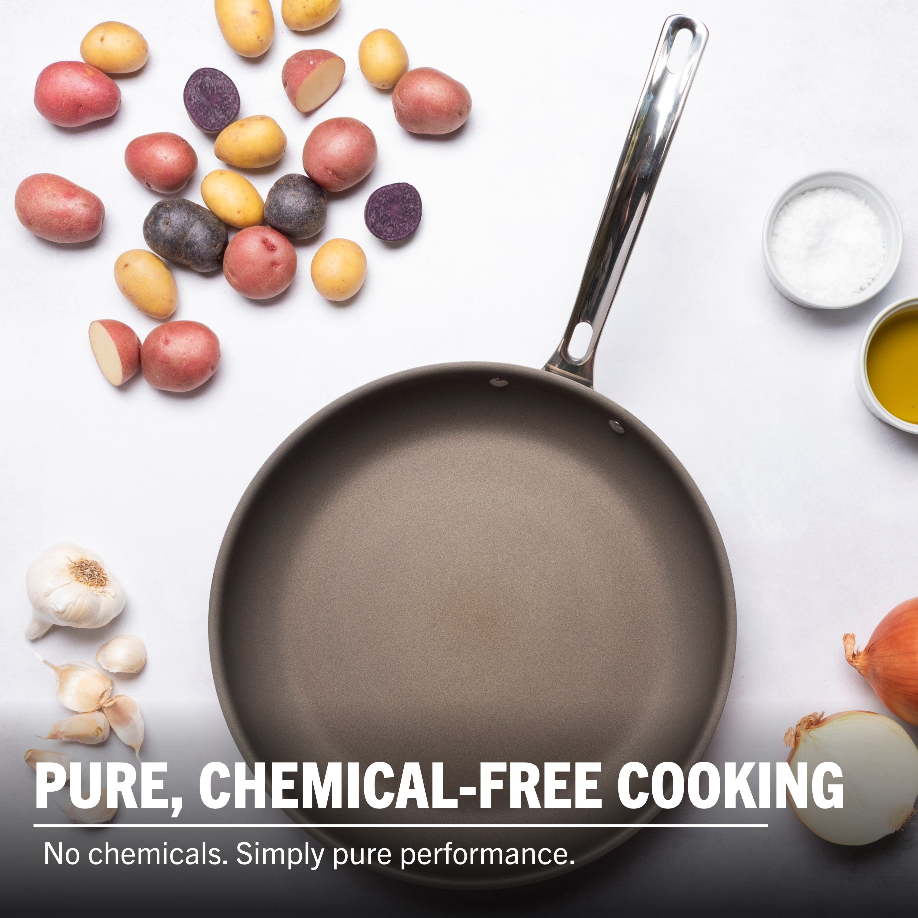 The Viking PureGlide Pro 3-Ply 12 Inch Fry Pan by Viking Culinary Products on a white surface with potatoes, garlic, onion, salt, and oil. Text: Pure, chemical-free cooking. No chemicals. Simply pure performance.
