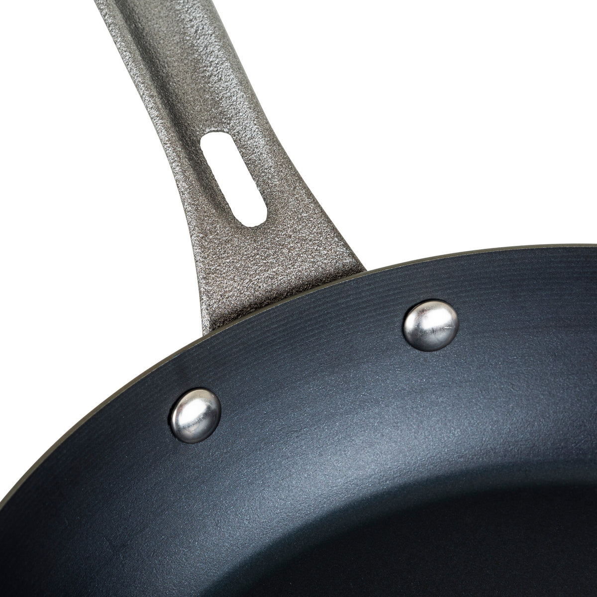 Close-up of the Viking Blue Carbon Steel 10-Inch Fry Pan by Viking Culinary Products, highlighting its textured metal handle secured to the black nonstick pan with two rivets.