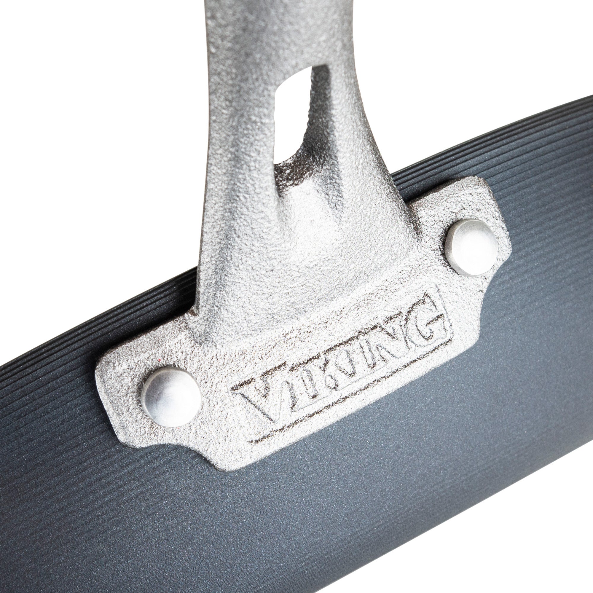 Close-up of a Viking Blue Carbon Steel 12-Inch Fry Pan handle attached to a black ridged surface, with VIKING engraved on the mounting plate and secured by two large rivets. Brand: Viking Culinary Products.